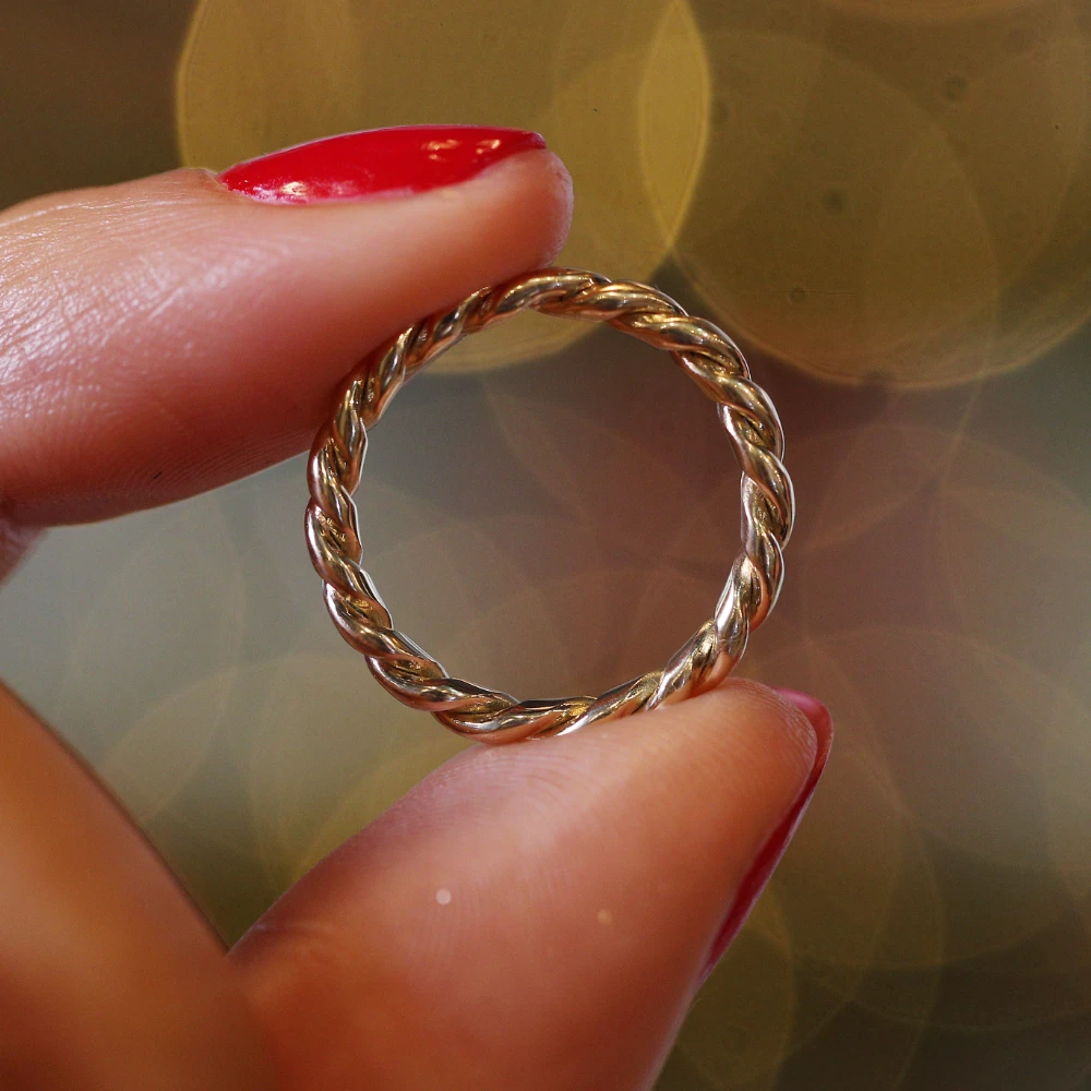 woman with seasonal gift ring PinPep Wee Ring_00016 close up of a medium skinned womans fingers with red nail polish holding a ring made by Lylie's from recycled electricals